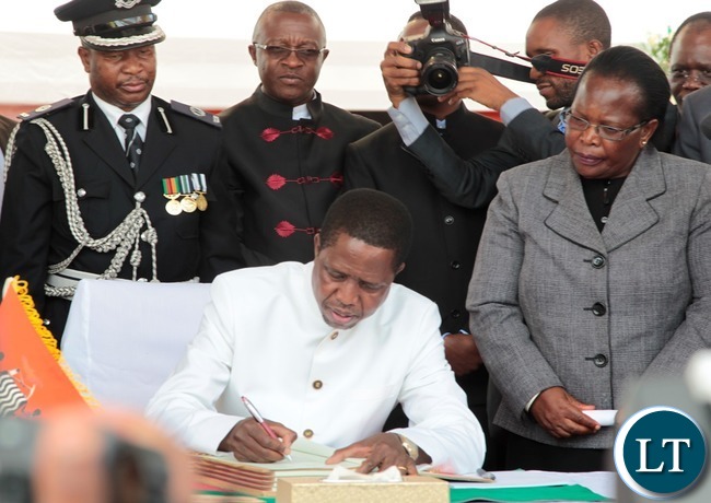 President of the Republic of Zambia, Mr. Edgar Chagwa Lungu signing the Constitution Bill whilst Chief Justice Irene Mambilima looks on during the Assenting of the Constitutional Bill Ceremony at Heroes Stadium yesterday 05-01-2016. Picture by ROYD SIBAJENE/ZANIS