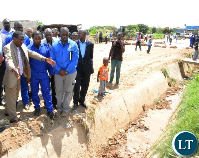Deputy Minister in the office of the Vice President Lawrance Sichalwe (left) inspects drainage during the tour of the Chunga bridge in Matero Deputy Minister in the office of the Vice President Lawrance Sichalwe (left) inspects drainage during the tour of the Chunga bridge in Matero