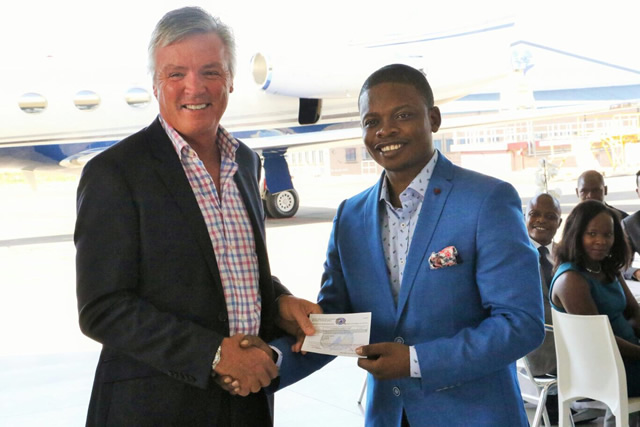 Gulf Stream Manager Larry Flynn presents the certificate of ownership to Prophet Bushiri