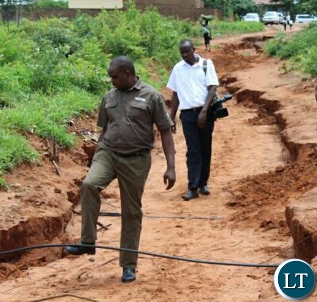 Livingstone District Commissioner Omar Munsanje inspects some water pipes that have been brought to the surface following heavy rains experienced in Livingstone