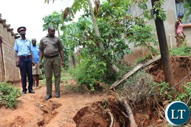 Livingstone District Commissioner Omar Munsanje inspects a loose Zesco pole that has been disturbed following heavy rains experienced in Livingstone