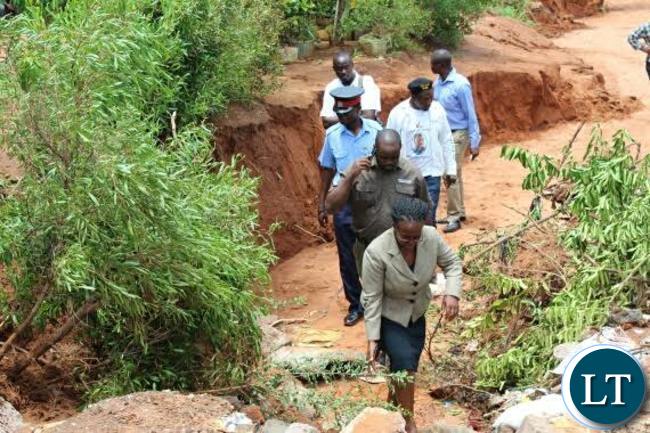 Livingstone Town Clerk Vivian Chikoti (in front) and Livingstone District Commissioner Omar Munsanje (behind) inspects some roads that have been damaged in Mwandi Extension following heavy rains experienced in Livingstone