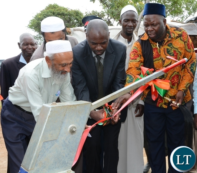 Chisamba District Commissioner Martin Chowa(c), Chief Chamuka VI of Mpikwa Village(r) and Muslim Social and Welfare Trust Representative Haroon Ghumra(l) officially handover the borehole to the people of Mpikwa Village in Chisamba District