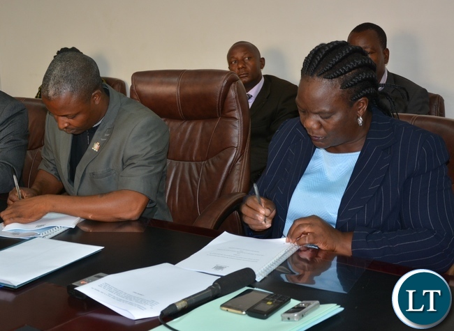 Permanent Secretary of the Ministry of Youth Sport and Child Development Ms Agnes M Musunga sings the memorandum of implementation of the empowerment scheme for the youth bus drivers with Secretary General of the Public and private bus drivers Associations of Zambia Mr Majuru
