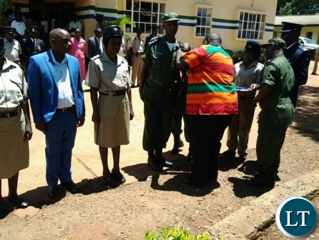 CHIPATA District Commissioner Kalunga Zulu confering a long serving medal on Kenneth Konayuma during Zambia Police Service day at Chipata Central Police