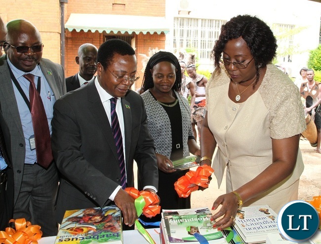 Minister of Community Development and Social Welfare,Emerine Kabanshi and her Permanent Secretary,Davy Chikamata cut the ribbon during the handover of books to Kitwe Community and development Social Welfare College by Books for Africa in Lusaka Minister of Community Development and Social Welfare,Emerine Kabanshi and her Permanent Secretary,Davy Chikamata cut the ribbon during the handover of books to Kitwe Community and development Social Welfare College by Books for Africa in Lusaka