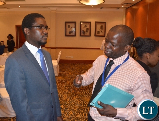 Inspector-Pensions and Insurance Authority Chishiba Kabungo chats with Director Consumer Protection Brian Lingela at the Press Briefing on fraud Prevention Month Media Breakfast at Southern Sun