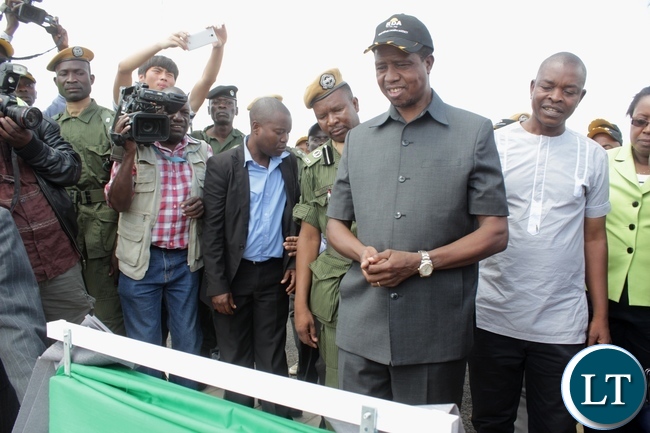 President Edgar Lungu (c) reads the message on the plaque after officially commissioning the Sioma Bridge built at a cost of K108.2million in Sioma District of Western Province,