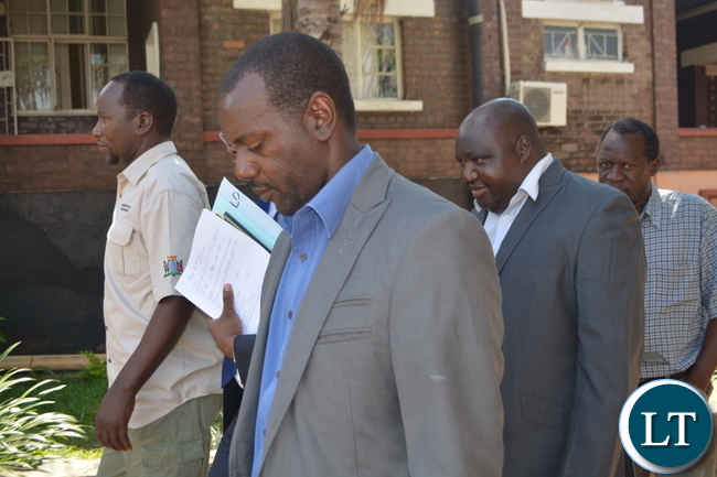 Milford Maambo hides behind his lawyer just after the Court hearing in Livingstone