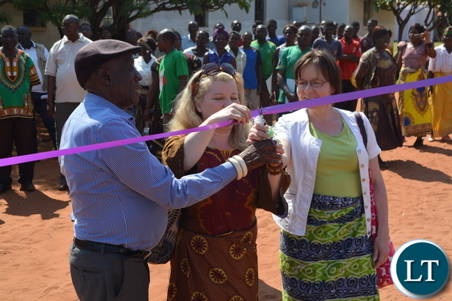 (from Left to Right) Chief Mukuni of the Toka Leya of Kazungula District, Global Dry Toilet Association of Finland (GDTAF) Project Manager Sari Huuhtanen and Ministry for Foreign Affairs Finland Programme Officer Sirpa Rajasarkka cut the ribbon during the handover ceremony of Dry Toilets in Mukuni Village