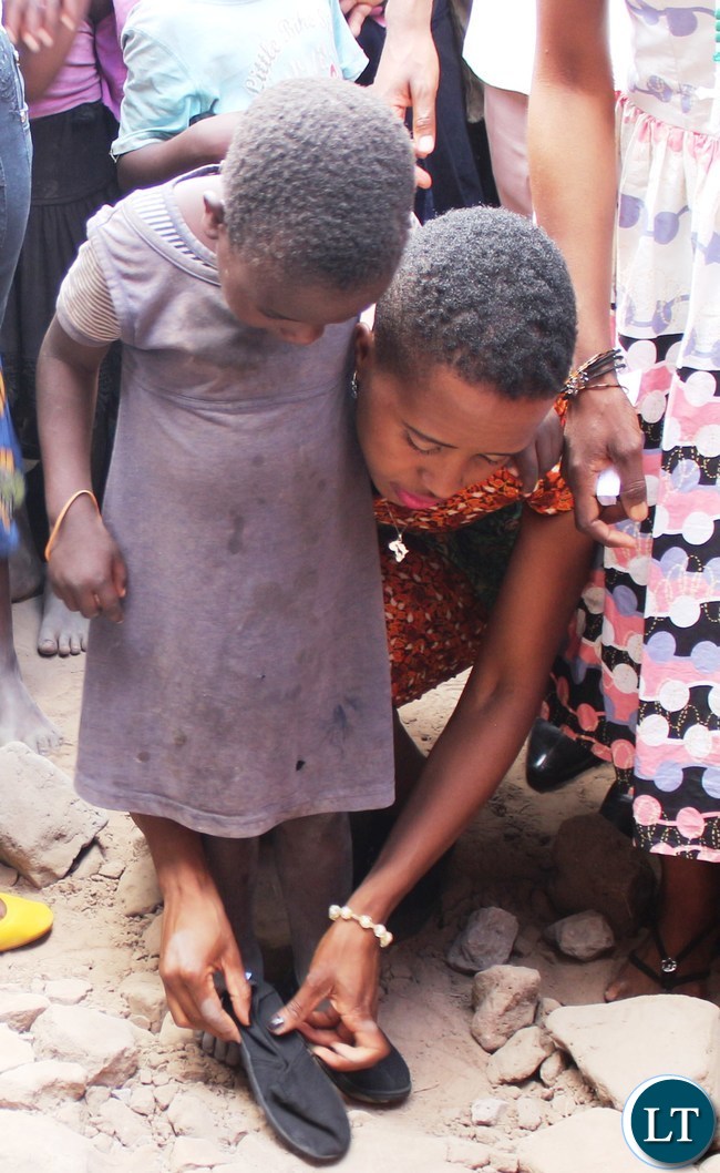 Ubulayo Charity organization founder Tasila Lungu with Mervis Chanda 8, a pupil at Mipango Community School in Mungwi district during her tour of Northern Province. This was after she made a donation of shoes to over 200 vulnerable and orphaned pupils at the school.