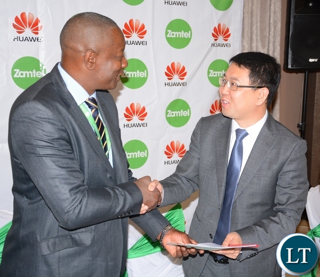 Zamtel CEO Mpanga Mwanakatwe and Managing Director Huawei Spawn Fan Wen exchange documents after Signing MOU of a Corporate Social Responsibility with Huawei Zambia provided 200, 000 USD and Zamtel Commitment to spend K2 million