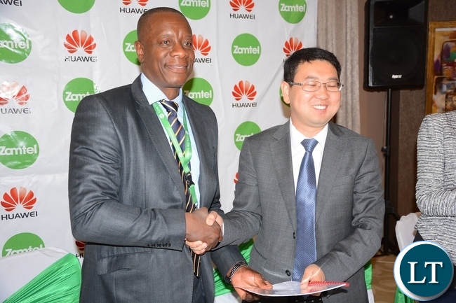 Zamtel CEO Mpanga Mwanakatwe and Managing Director Huawei Spawn Fan Wen exchange documents after Signing MOU of a Corporate Social Responsibility with Huawei Zambia provided 200, 000 USD and Zamtel Commitment to spend K2 million