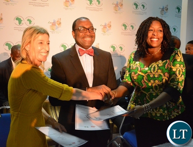 African Development Bank President Akinwumi Adesine (c) Managing Director Dangote Foundation Zouera Youssoufou (r) and Jamie Cooper Chair and President of Big Win Philanthropy exchanging documents after signing the connection with the Technical Partnership on Nutrition at the Achieving Nutritional Security conference