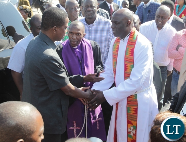 President Edgar Lungu being welcomed at Kabundi Kapisha UCZ Congregation Bishop Sichilima (c) and Rev. Alinjavwa Simumba shortly before Church services
