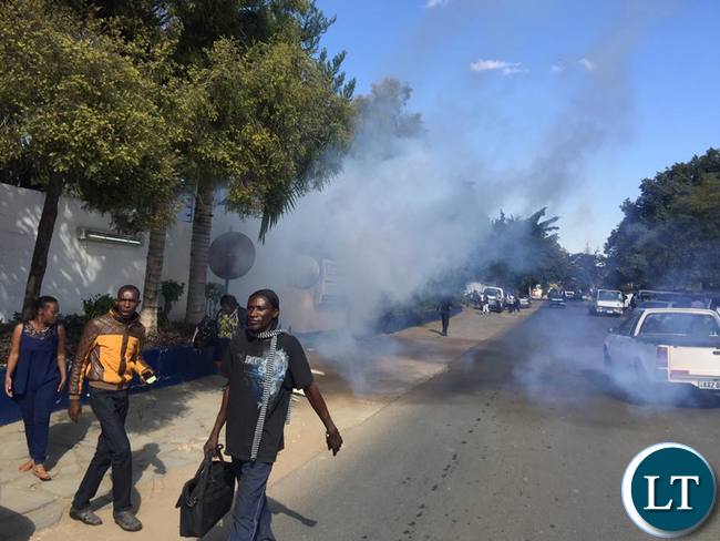 Post workers run for safety after teargas is fired by Zambia Police