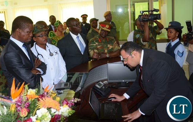 Sycom Africa Business Development Manager Mina Karas(r) shows President Lungu(l) the Digital login system for Patients at the reception at the State of the Art Zambia Air Force Hospital