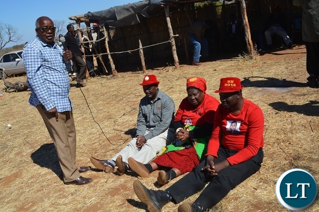 Former Southern Province Minister Daniel Munkombwe(holding microphone) counsels UPND Livingstone parliamentary candidate Mathews Jere(left in red hat) and mayoral candidate Eugene Mapuwo( seated third from left) during a rally to drum up support for UPND Presidential,parliamentary and local Government candidate at Mahululu clinic in Livingstone