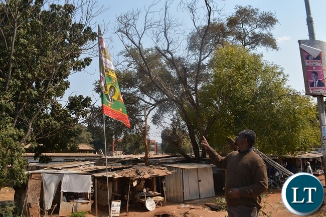Jesuit Centre for Theological Reflection(JCTR) director Fr Leonard Chiti points at a PF/UPND flag at old town centre market in Livingstone