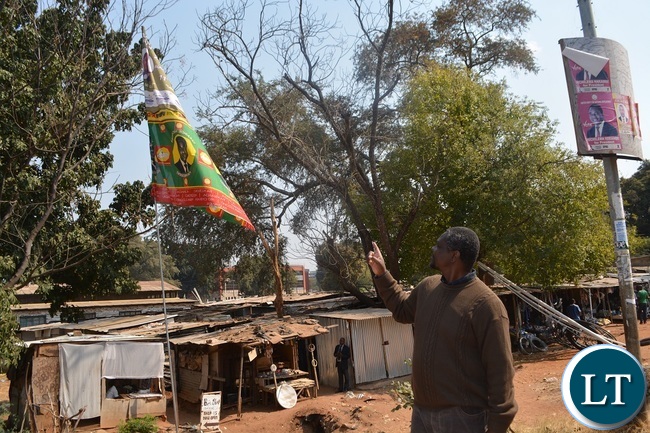 Jesuit Centre for Theological Reflection(JCTR) director Fr Leonard Chiti points at a PF/UPND flag at old town centre market in Livingstone