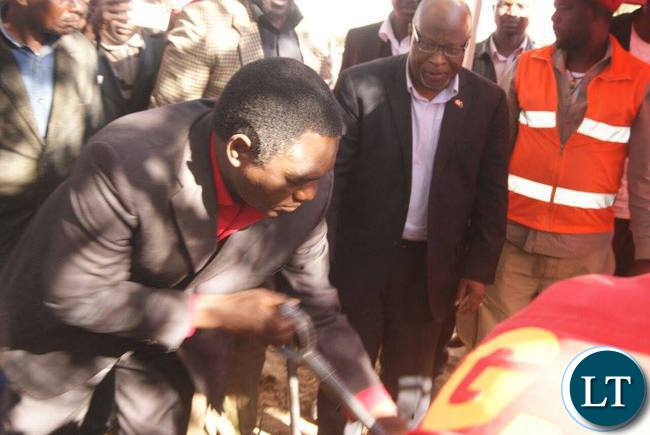 HH assisted by Dr Nevers Mumba helps out at the grave of late Mr Muntanga