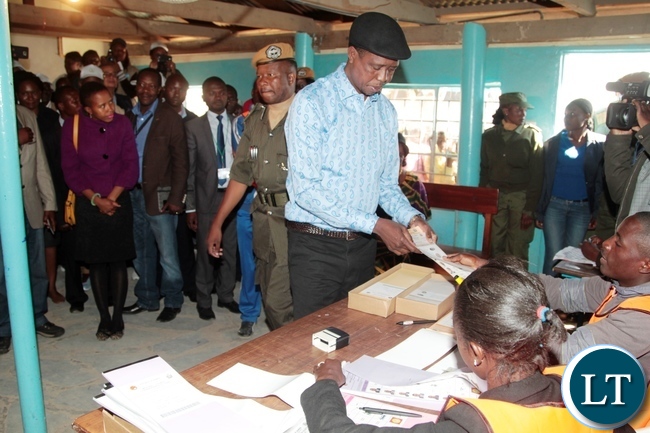 President Edgar Lungu receive the ballot paper from polling assistant shortly before casting his vote in Chawama Constituency at Apostolic Faith Church