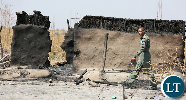 ZAF Pilot walking through burnt Chikwato Village
