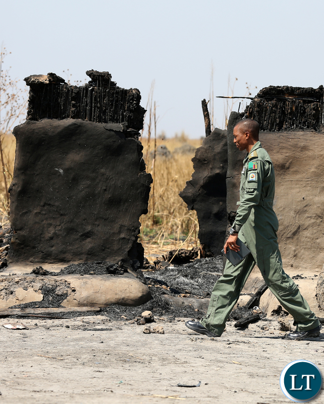 ZAF Pilot walking through burnt Chikwato Village