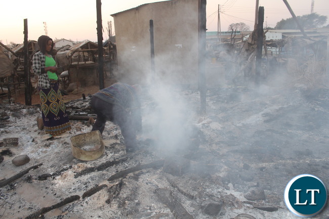 A business men trying to salvage something from what was once his market stalls gutted by fire started by UPND cadres yesterday during a protest.