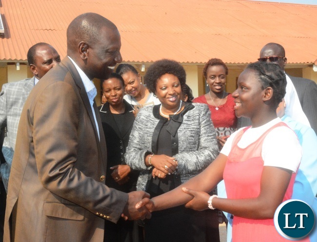 Kenyan Vice President William Ruto(r) greets a grade 8 pupil Agnes Katenga(l) during his visit to the Ophanage