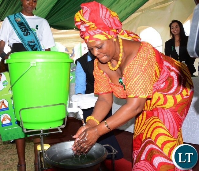 First Lady Esther Lungu washes her hands to demonstrate the 6 steps to Hand washing during Giacomo Global Hand Washing Day at North mead Primary School