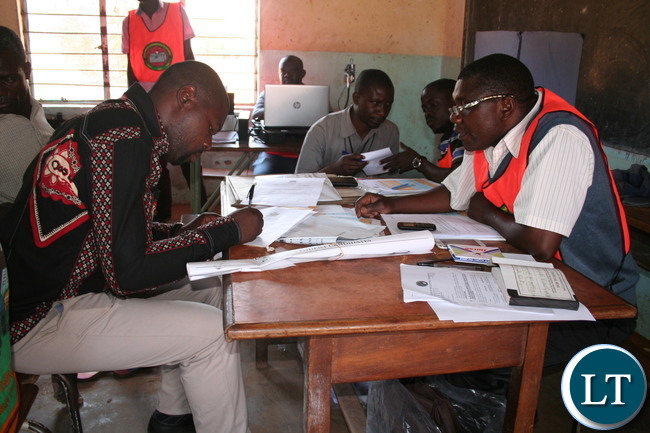 PATRIOTIC candidate for Kalumbila council chairperson Slavian Bulaya (r ) filling in his nomination papers as returning officer Geoffrey Kaleji looks on at Mwajimambwe primary school on Thursday in Kalumbila district.