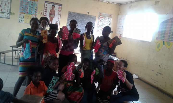 Chilufya presenting girls with reusable sanitary pads