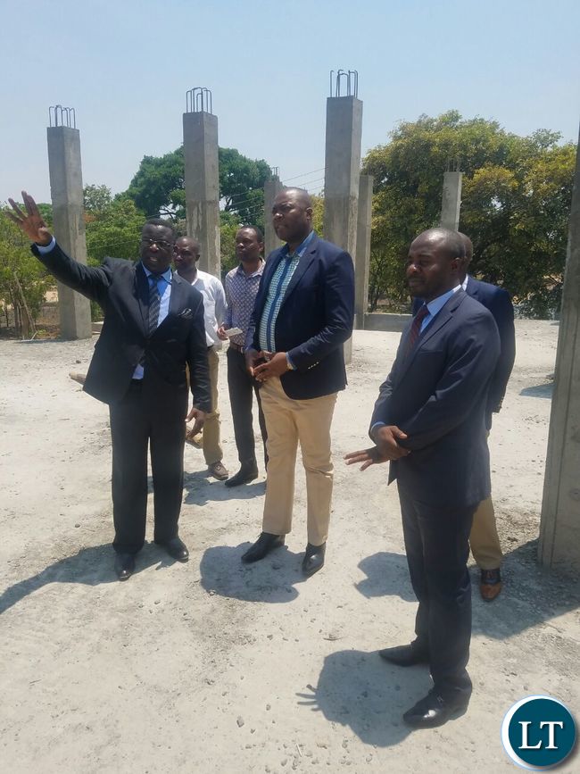 Getting a briefing from Church Reverand George Chanda on the progress on the constrcution of a new Church building