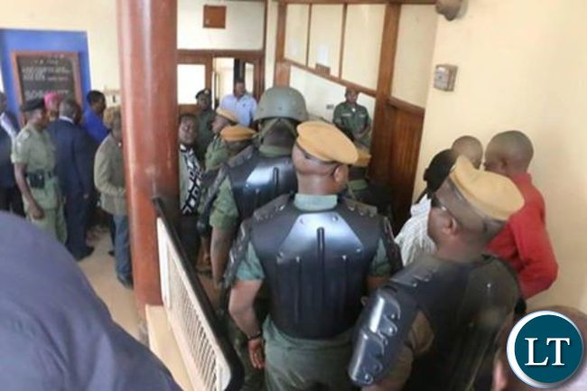 Police officers leading HH and GBM (not in picture) in police cells