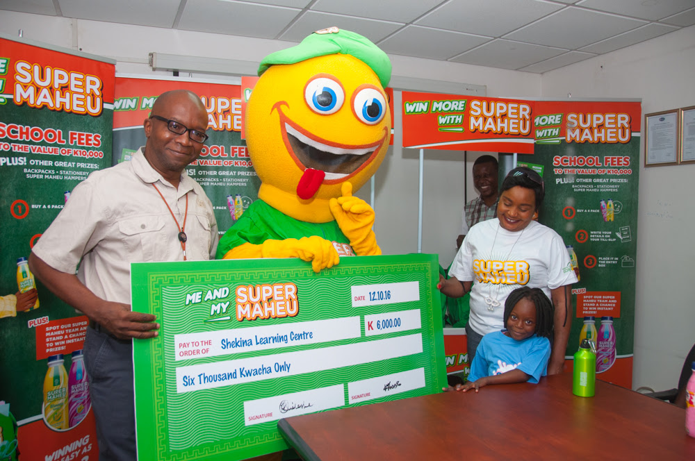 Super Maheu general manager Panji Banda presents back-to-school awards to competition winners.
