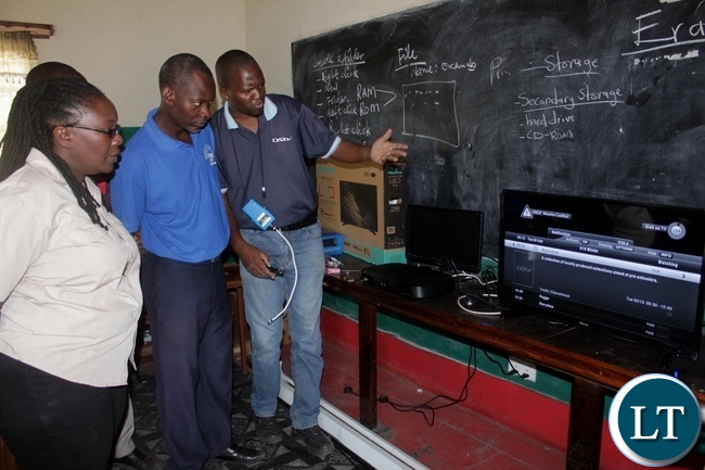 Digital Satellite Television (DSTV) Installer Sebastian Muntanga (r) instructing Kanyonyo Secondary School teachers how to operate DSTV Explorer Decoder and a TV set donated by Multi-Choice Zambia in partnership with Ministry of General Education in a program of installing free DSTV Educational Bouquets in schools in Mongu Digital Satellite Television (DSTV) Installer Sebastian Muntanga (r) instructing Kanyonyo Secondary School teachers how to operate DSTV Explorer Decoder and a TV set donated by Multi-Choice Zambia in partnership with Ministry of General Education in a program of installing free DSTV Educational Bouquets in schools in Mongu