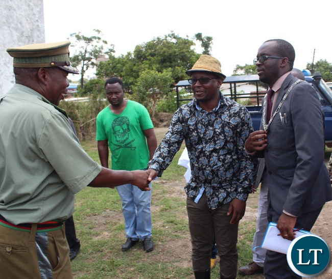 Kitwe District Commissioner Chanda Kabwe shakes hands with Copperbelt Correctional Services commanding Officer, Wilson Mbewe when he toured old Kitwe remand Prison.