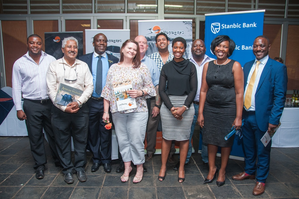 Stanbic Bank Zambia Chief Executive Charles Mudiwa, right, and Head of Personal and Business Banking Mukandi Chibesakunda, second right, with draw winners at the Stanbic travel expo.