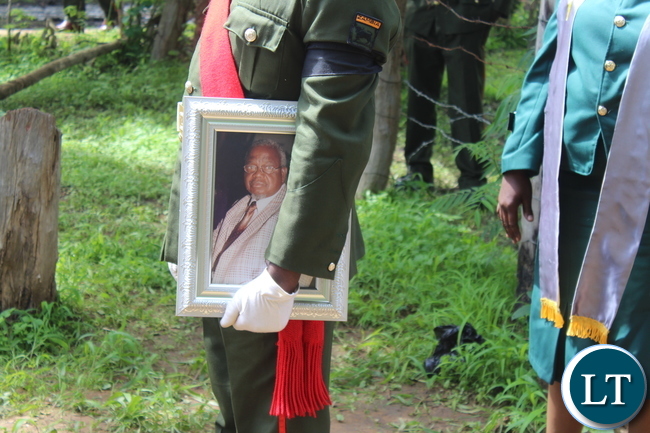 A service man carrying a portrait of late Ben Kapita
