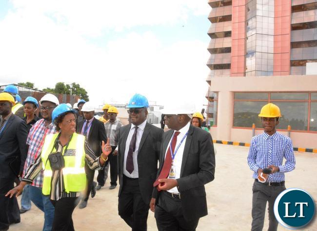 Minister of Labour Joyce Simukoko (in yellow reflector) flanked by National pension Scheme Authority Director General Yollard Kachinda (2nr) and Zambia National building Society Managing Director Joseph Chikolwa (third from right) touring the Society Business Park in Lusaka