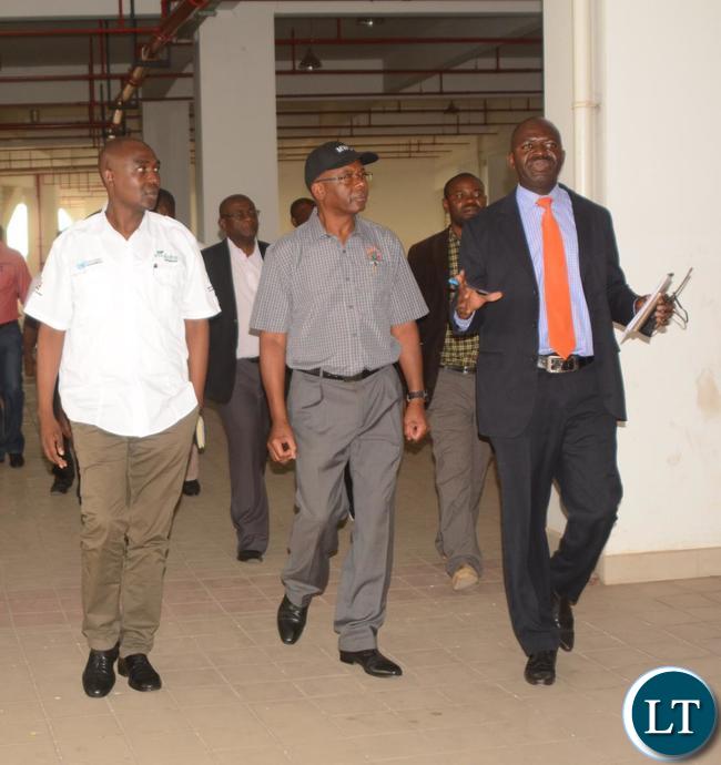 Ministry of Housing and Infrastructure Development Structural Engineer Francis Mundanya(l) explaining to the Minister of Works and Supply Mathew Nkhuwa(c) and Lusaka Province Minister Japhen Mwakalombe(r) the Development of the works during the tour of the Infrastructure at Heroes Stadium