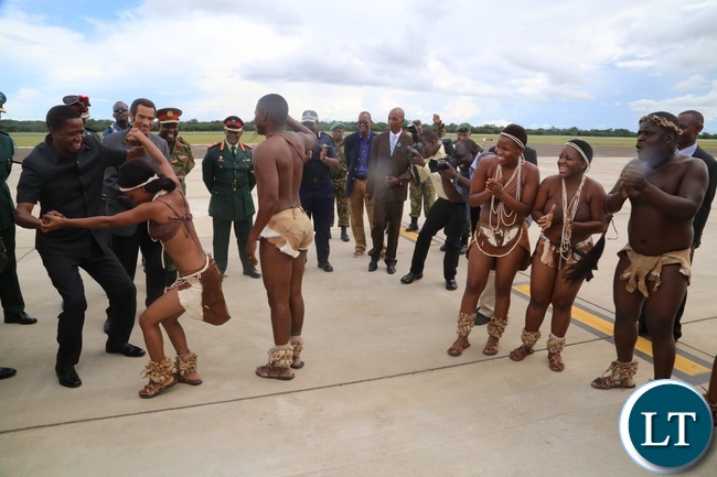 President Edgar Lungu joins in Matsosangwao traditional arts group as Botswana President Ian Khama (r) looks on shortly after his arrival at Kasane Airport