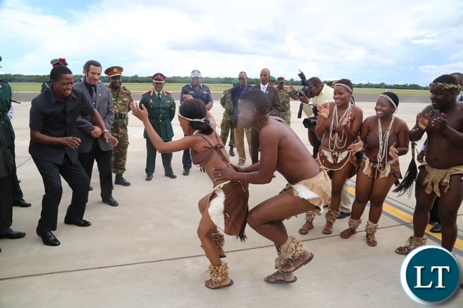 President Edgar Lungu joins in Matsosangwao traditional arts group as Botswana President Ian Khama (r) looks on shortly after his arrival at Kasane Airport