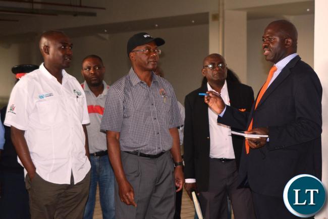 Ministry of Housing and Infrastructure Development Structural Engineer Francis Mundanya(l) explaining to the Minister of Works and Supply Mathew Nkhuwa(c) and Lusaka Province Minister Japhen Mwakalombe(r) the Development of the works during the tour of the Infrastructure at Heroes Stadium