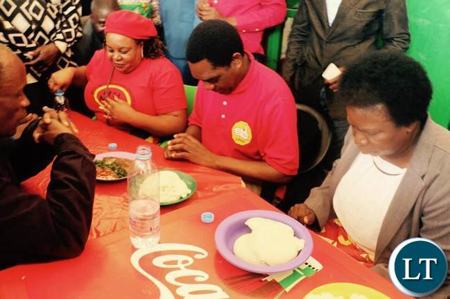 HH says a prayer before eating a plate of Nshima at Chelstone market