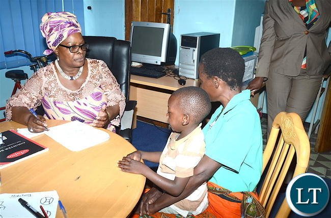 First Lady Esther Lungu interacts accesses one of the physically challenged children Benjamin Banda at Zambia Institute of Special Education where she flagged off the International Women's Day activities under the theme: Promoting inclusiveness in economic participation as a means of attending sustainable development on Friday, March 3,2017 -Pictures by THOMAS NSAMA