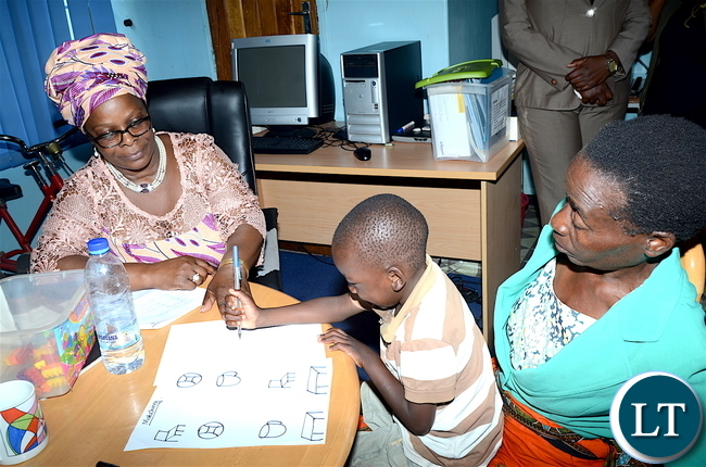 First Lady Esther Lungu interacts accesses one of the physically challenged children Benjamin Banda at Zambia Institute of Special Education where she flagged off the International Women's Day activities under the theme: Promoting inclusiveness in economic participation as a means of attending sustainable development on Friday, March 3,2017 -Pictures by THOMAS NSAMA