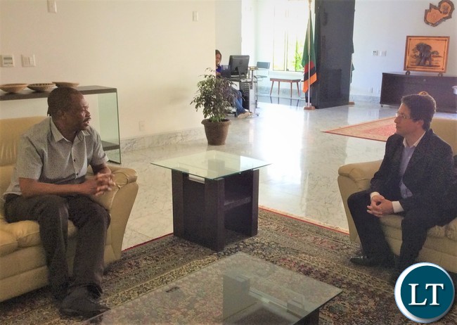 Defence Advisor at the Zambian Mission in Brasilia Colonel Godwin Chenda chatting with Embraer Sales Engineering Manager Mr. Gustavo Siqueira when he passed through the Chancery to collect the Visa for Zambia.