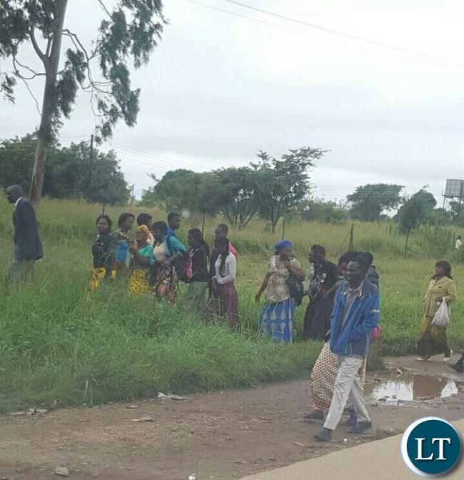 Lusaka residents braving the morning showers to line up for free food